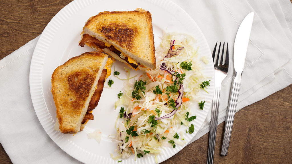 Slap down grill cheese sandwich filled with perogies, served with slaw.